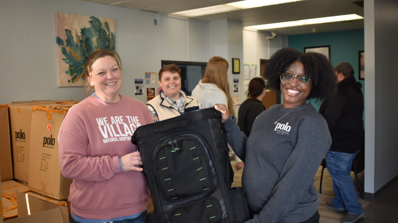 two women holding donated carry bag